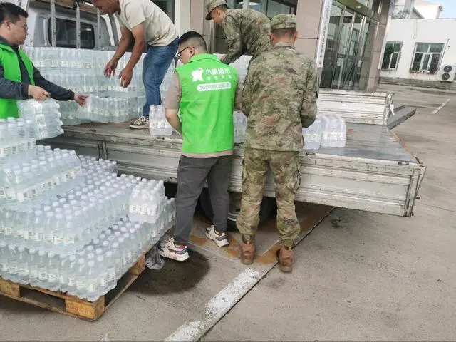 ▲美團小象超市工作人員與懷柔北房鎮救援人員搬運救災物資（王磊 攝）